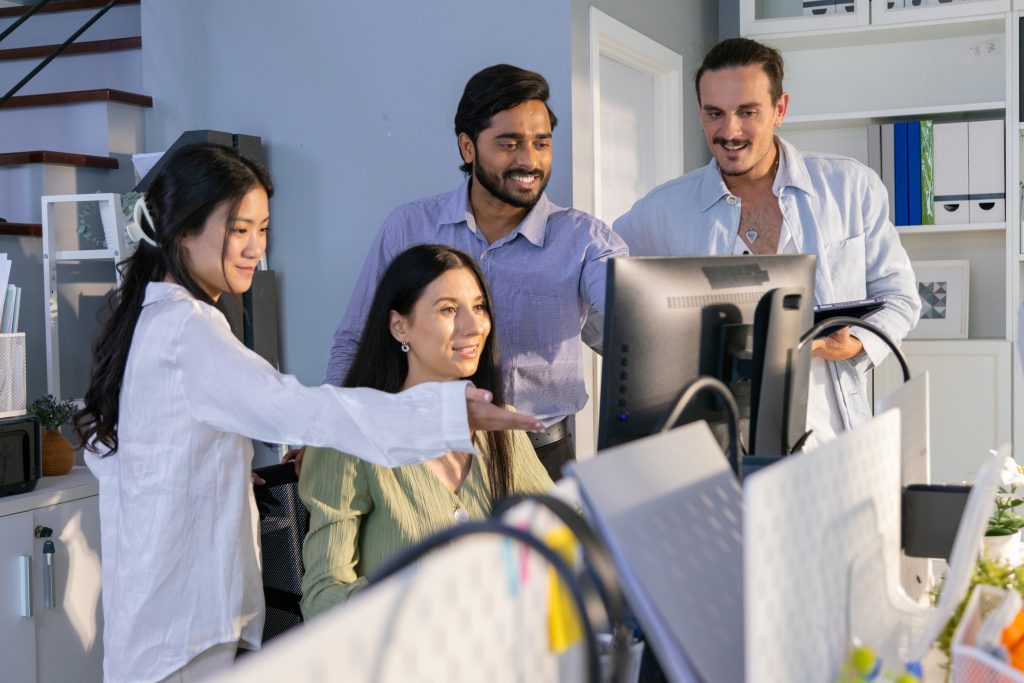 A diverse group of professionals collaborating in a modern office environment, engaged in discussion and teamwork.